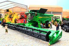 Load image into Gallery viewer, Britains John Deere S7 900 tracked combine harvester model with a wide cutting header displayed among colourful farm machinery in a realistic agricultural scene
