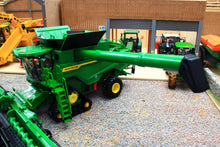 Load image into Gallery viewer, Britains 1:32 scale John Deere tracked combine harvester model with header and unloading auger displayed in a detailed farm diorama with agricultural buildings