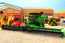 Load image into Gallery viewer, Britains John Deere S7 900 tracked combine harvester model with wide header displayed among tractors and farm machinery in a detailed farmyard scene