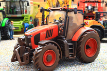 Load image into Gallery viewer, Weathered Britains Kubota M7.154 4WD tractor model in red with detailed cab and chunky treaded tyres on a miniature farm scene
