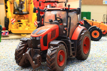 Load image into Gallery viewer, Weathered Britains Kubota M7.154 4WD tractor model in red displayed on a farm diorama with agricultural equipment in 1:32 scale