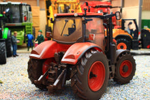 Load image into Gallery viewer, Weathered Britains Kubota M7 154 4WD tractor model in red with detailed cab and chunky tyres displayed on a miniature farm diorama