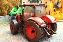 Load image into Gallery viewer, Britains weathered Kubota M7.154 4WD tractor model in red with detailed cab and chunky tyres on a miniature farm diorama