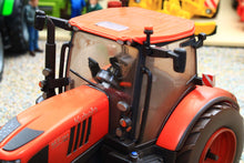 Load image into Gallery viewer, Weathered Britains Kubota M7.154 4WD tractor model in red with an enclosed cab and detailed controls shown close up