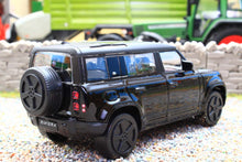 Load image into Gallery viewer, Burago 1:43 scale black Land Rover Defender 110 diecast model displayed on gravel with detailed wheels windows and spare tyre