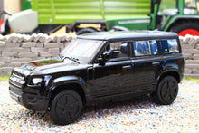 Load image into Gallery viewer, Burago 1:43 scale black Land Rover Defender 110 diecast model car displayed on gravel beside miniature farm machinery