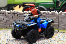 Load image into Gallery viewer, Diecast Masters 1:32 scale blue quad bike with a rider in a red helmet and black jacket displayed on gravel beside a miniature stone wall and green tractor