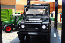 Load image into Gallery viewer, GT Spirit Models 1:18 scale Land Rover Defender 110 in dark grey shown from the front on a display base in a miniature farm diorama with a tractor behind