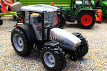 Load image into Gallery viewer, ROS Hurlimann XB Max 100 4WD tractor model in grey and black with an enclosed cab and rugged tyres displayed on a gravel farm scene