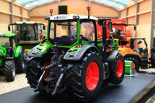 Load image into Gallery viewer, Universal Hobbies Fendt 516 Vario 4WD tractor model in green with red wheels displayed in a farm machinery showroom 1:32 scale collectible tractor model