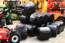 Load image into Gallery viewer, Universal Hobbies 1:32 scale black wrapped round silage bales arranged in a farm diorama Only the bales are included machinery shown is not included
