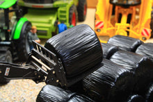 Load image into Gallery viewer, Universal Hobbies 1:32 scale black wrapped round silage bales displayed in a farm diorama, with only the bales included